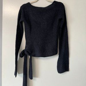 Long sleeve sweater top with side bow accent.